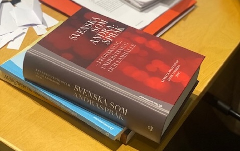 Visar en bokhög med boken Svenska som andraspråk överst